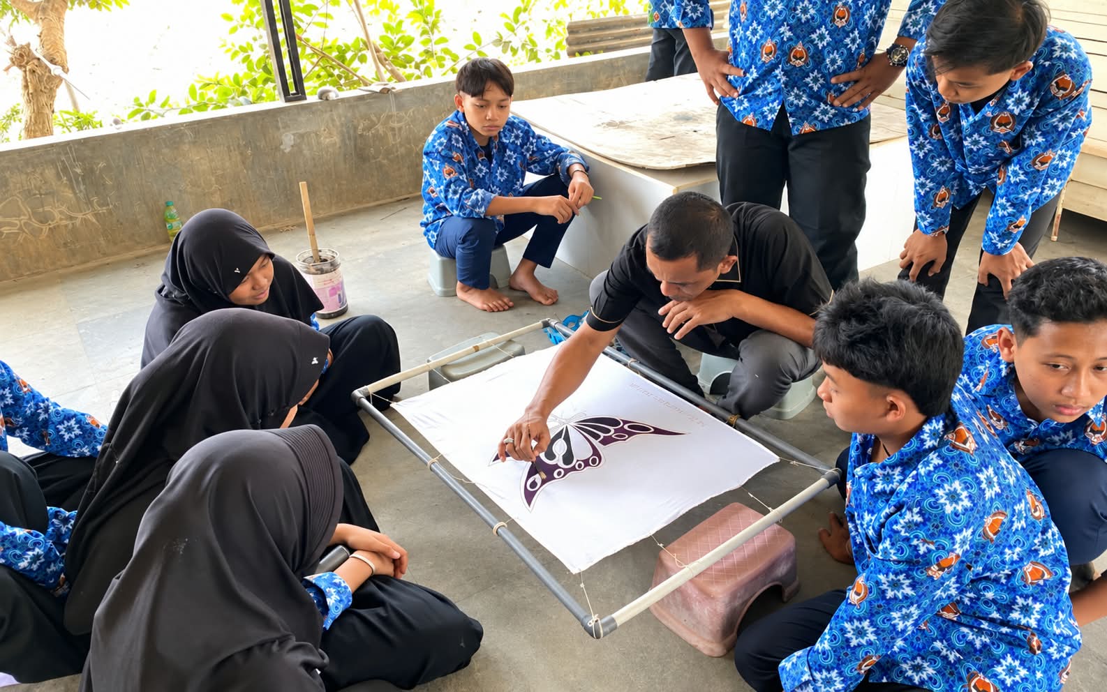 Siswa kelas IX MTs Nurul Islam mengamati proses membatik dengan saksama di DK Batik Madura.